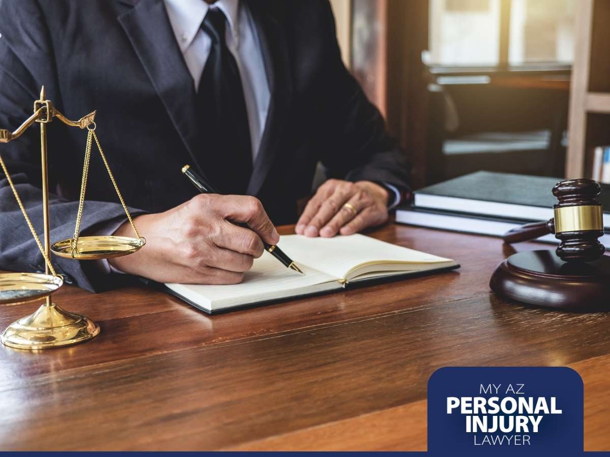 An Arizona personal injury lawyer at his desk signing documents